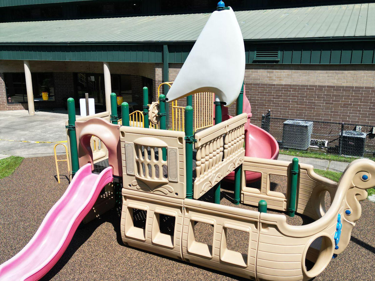 Pirate ship-themed playground with a pink slide and white sail