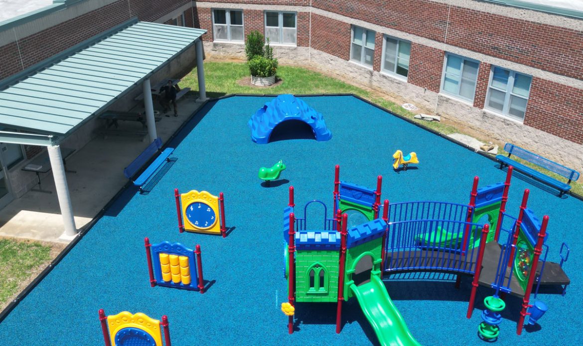 A playground featuring a blue and black play area, equipped with slides and climbing structures for children.