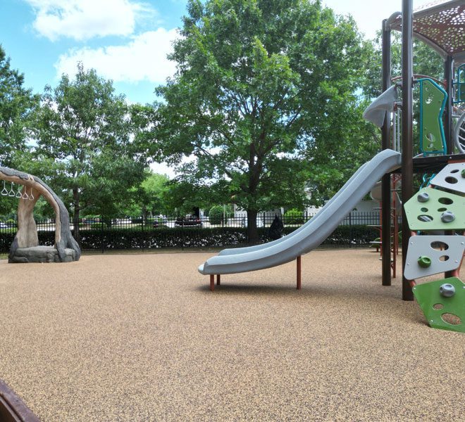 Children’s play area with slider installed on poured in place rubber playground surfacing for enhanced safety and comfort
